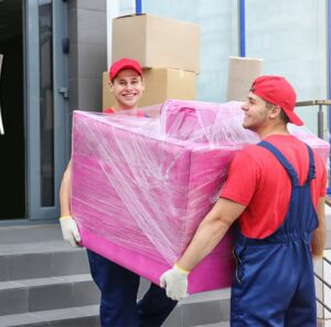 Zwei Umzugshelfer tragen ein in Folie gepacktes Möbelstück – Umzug in Bad Homburg