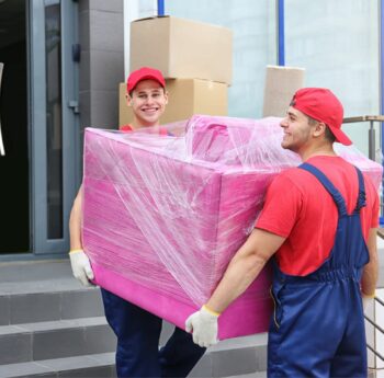 Zwei Umzugshelfer tragen ein in Folie gepacktes Möbelstück – Umzug in Bad Homburg