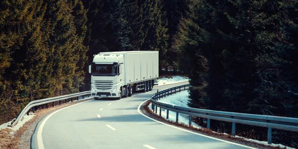 Klaviertransport Bad Homburg: Lkw fährt auf einer kurvigen Straße durch den Wald