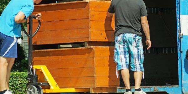 Möbellift Bad Homburg: Zwei Helfer tragen einen Holzschrank aus einem Lkw
