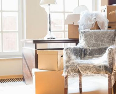 Kartons zwischen Sesseln in einem hellen Zimmer – Umzugskartons Bad Homburg